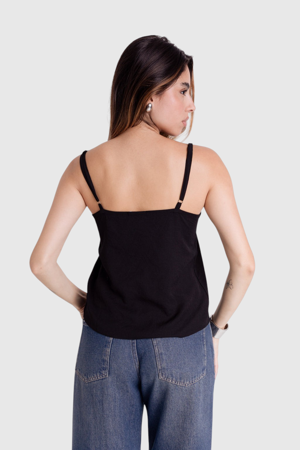 Modelo de costas vestindo blusa preta de alça fina com regulagem da LA MAGIE | Roupas Femininas Básicas e Estilosas