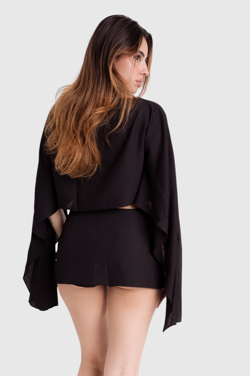 Modelo veste blusa preta LA MAGIE | Roupas Femininas Básicas e Estilosas estilo capa em viscose rústica fluida.