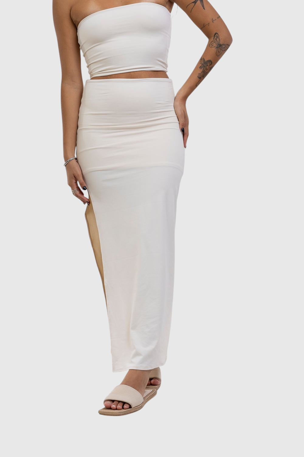 Modelo veste saia midi off-white com fenda lateral da LA MAGIE | Roupas Femininas Básicas e Estilosas em poliamida.
