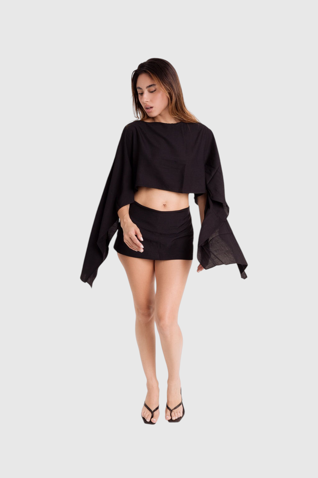 Modelo veste blusa preta estilo capa LA MAGIE em viscose rústica com modelagem ampla e mangas fluidas