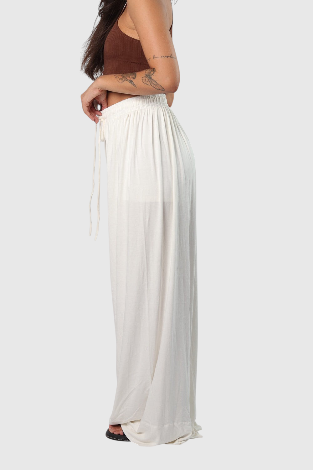 Pantalona off white LA MAGIE em viscolycra com cós de elástico e cordão, vista lateral em modelo