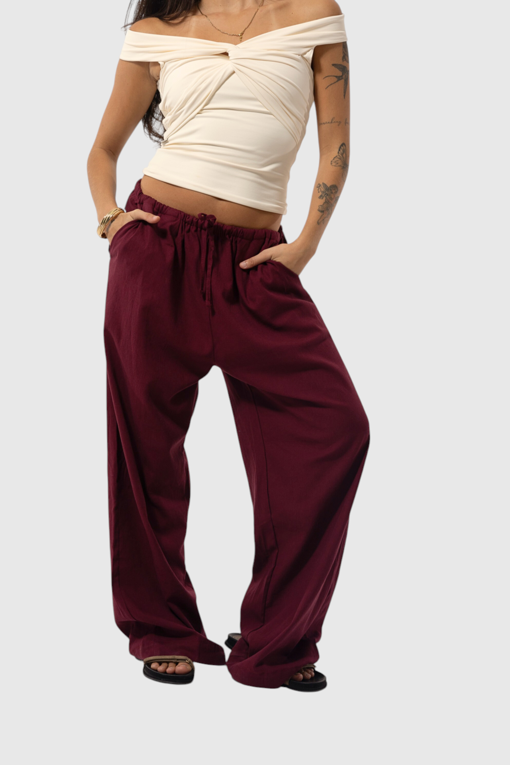 Modelo veste calça básica de linho bordô da LA MAGIE | Roupas Femininas Básicas e Estilosas com cintura ajustável.