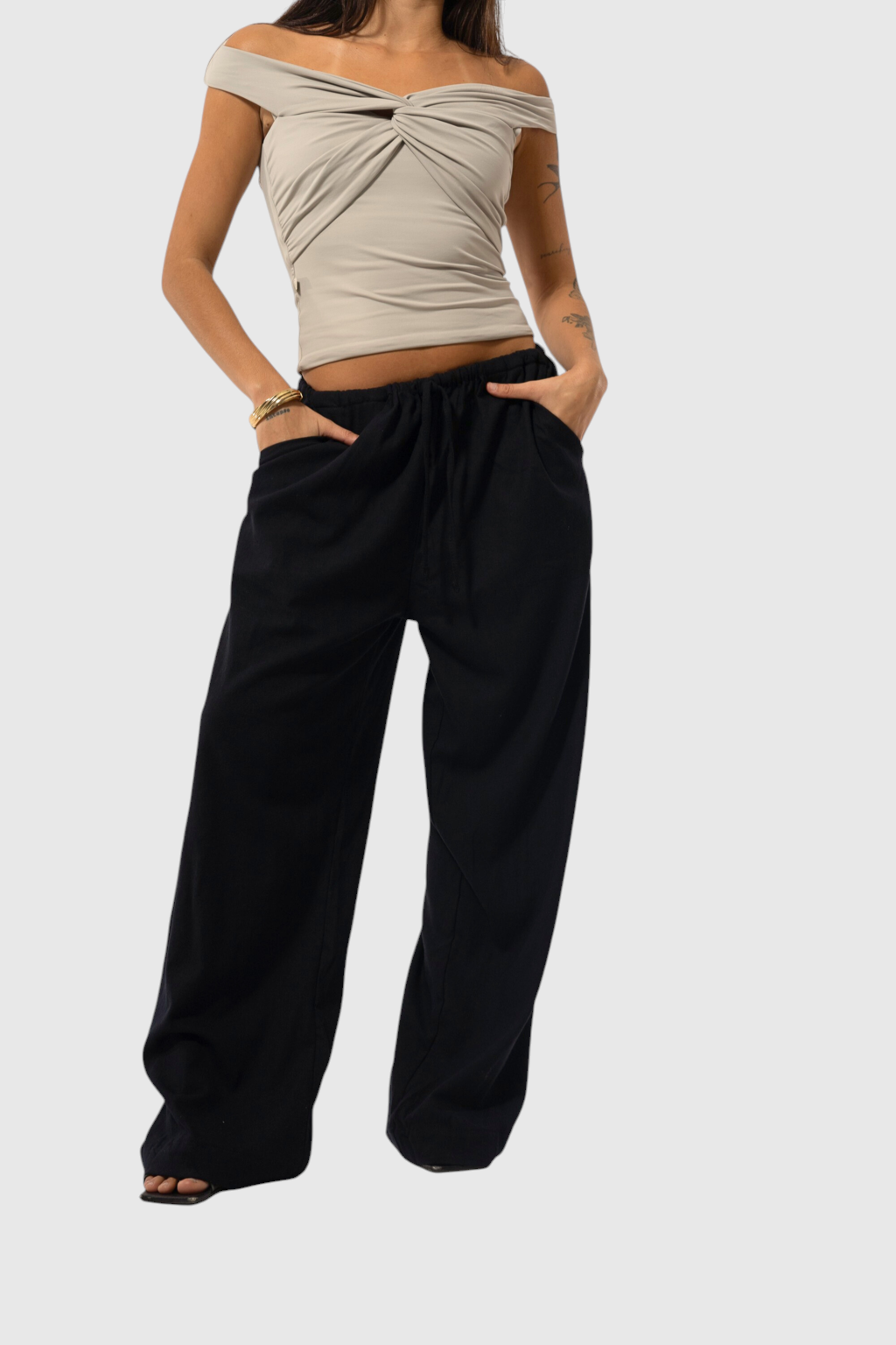 Modelo vestindo calça básica de linho preta com ajuste na cintura e bolsos laterais da marca LA MAGIE | Roupas Femininas Básicas e Estilosas