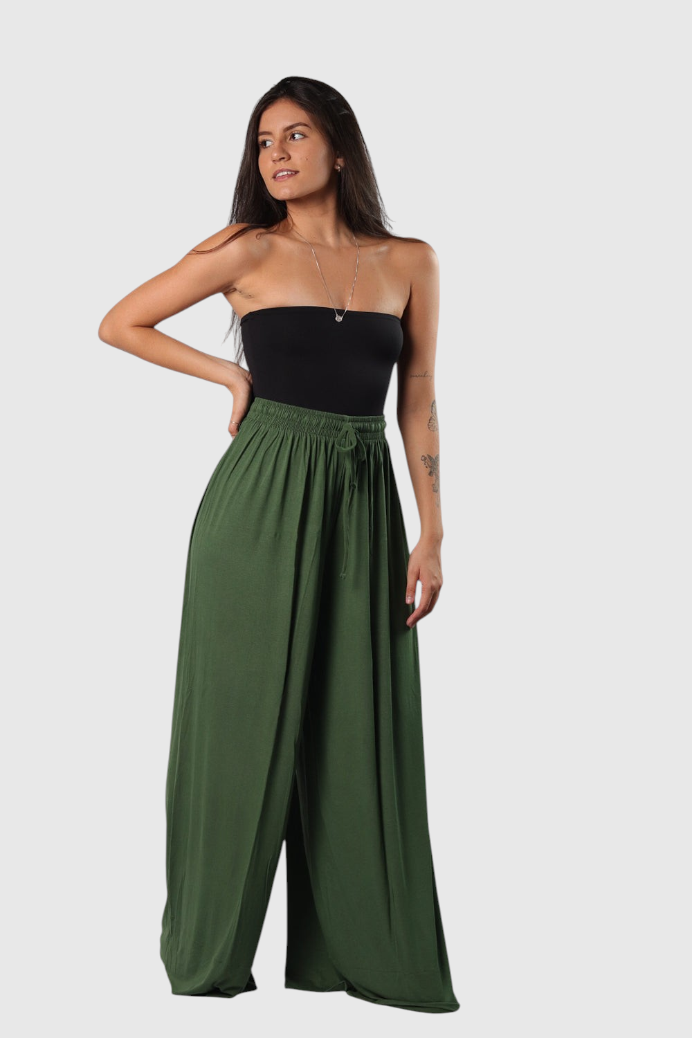 Modelo veste calça pantalona verde LA MAGIE em viscolycra com cós de elástico e cordão, combinada com top tomara que caia