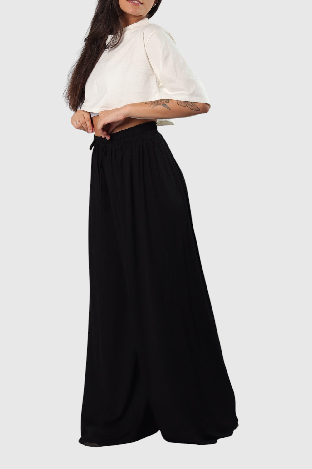 Modelo vestindo calça pantalona preta LA MAGIE em viscolycra com cós de elástico e cordão, estilo casual e confortável.