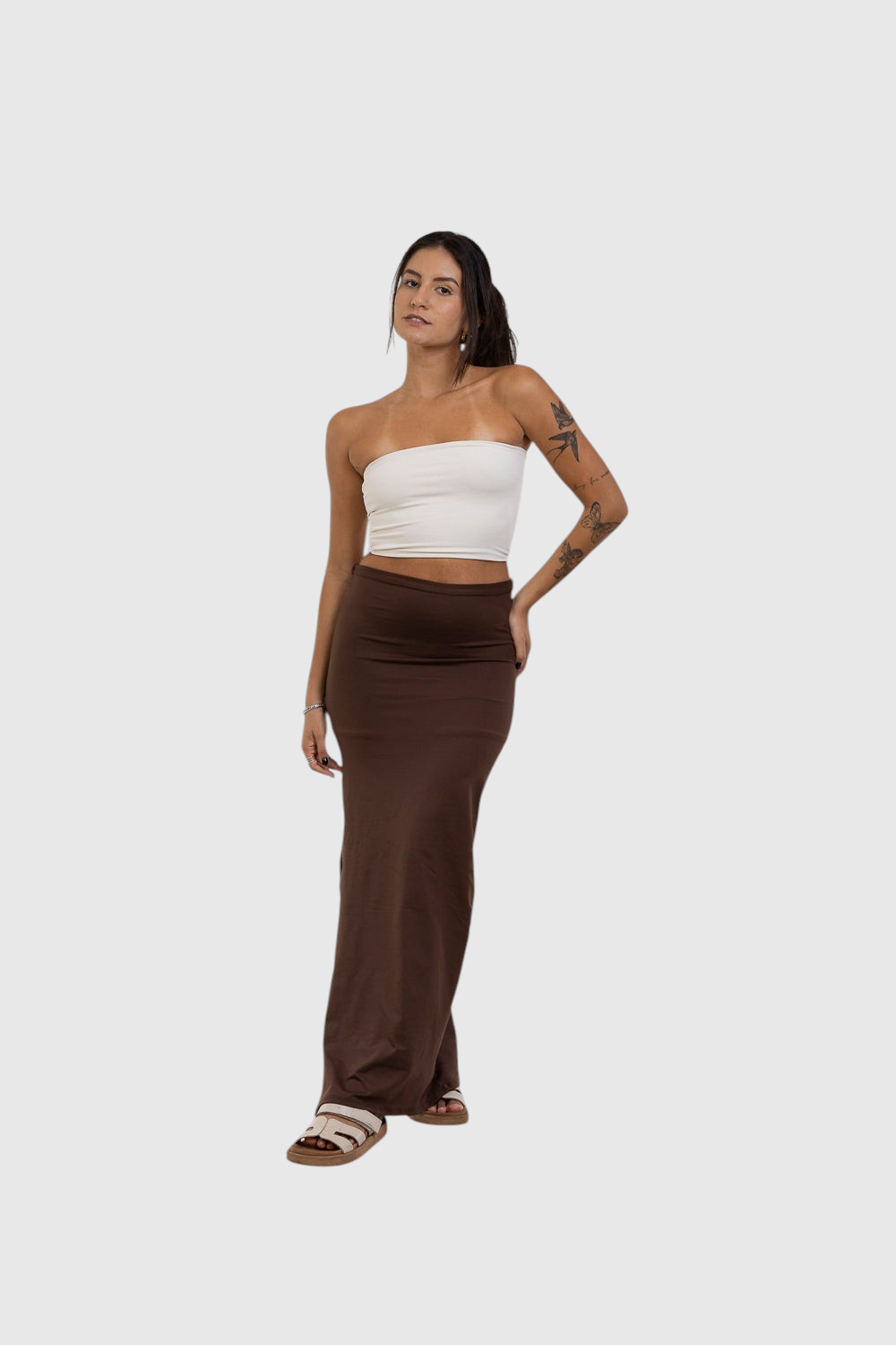Modelo veste saia midi marrom com fenda lateral da LA MAGIE | Roupas Femininas Básicas e Estilosas em poliamida.
