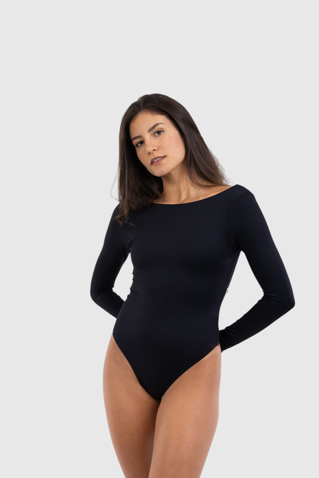Modelo veste body LA MAGIE preto de manga longa com decote quadrado, feito em poliamida flexível e forro duplo.