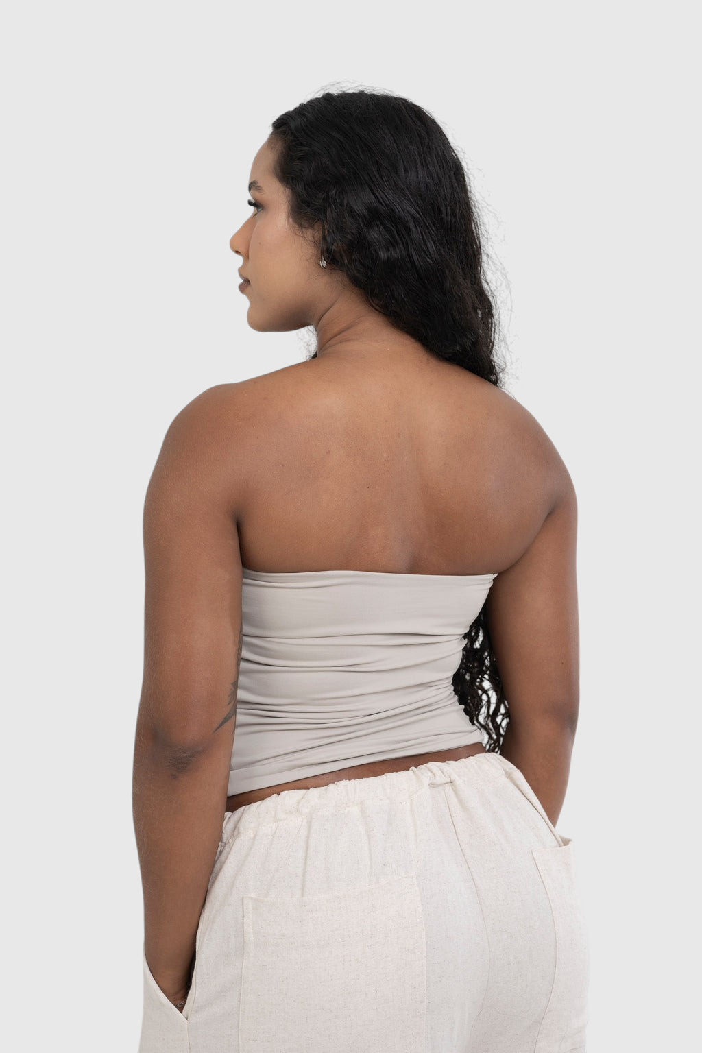 Modelo de costas vestindo blusa tube bege LA MAGIE Roupas Femininas Básicas e Estilosas em suplex de poliamida premium