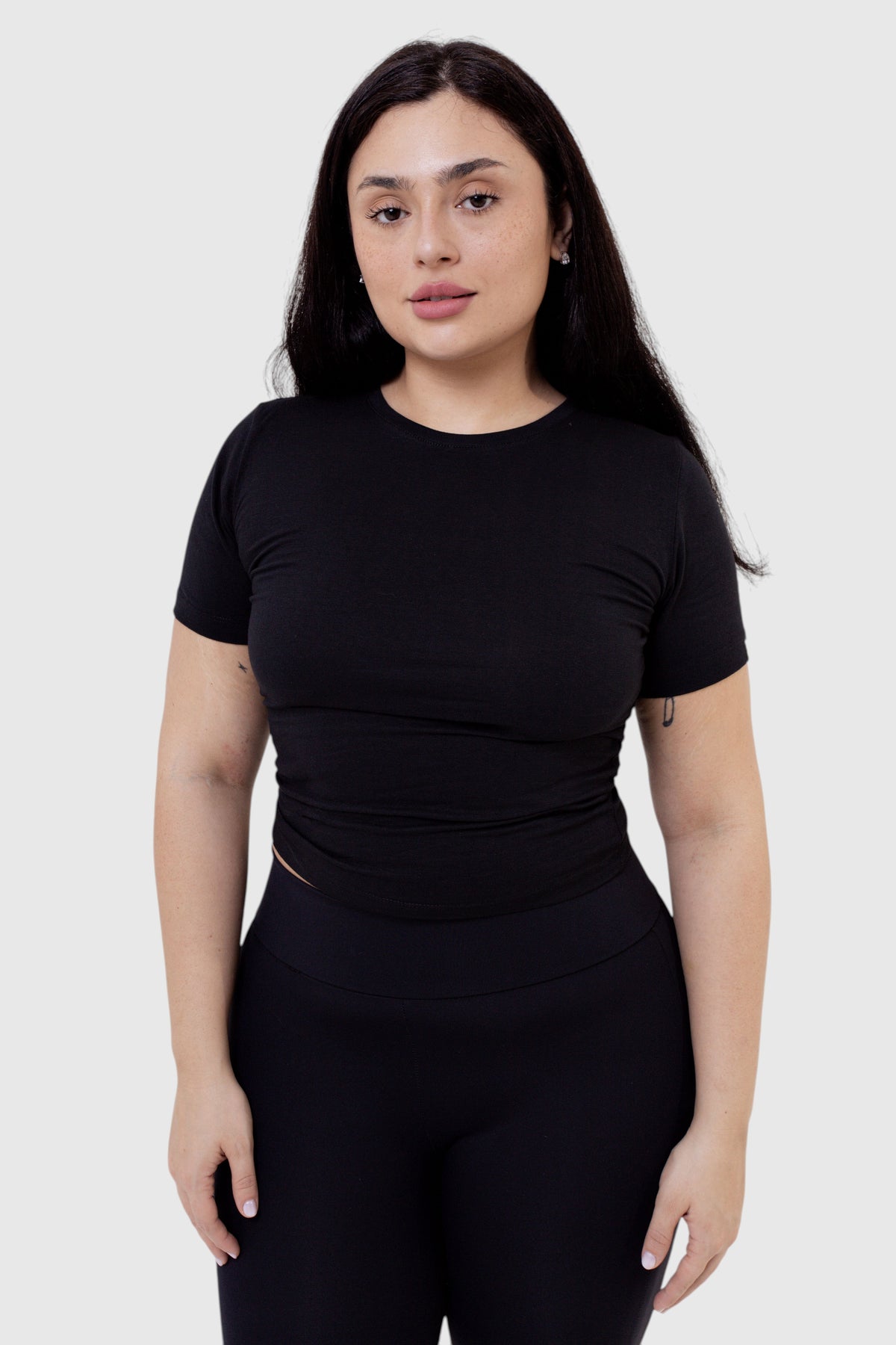 Modelo vestindo baby tee preta de algodão da LA MAGIE | Roupas Femininas Básicas e Estilosas em fundo branco