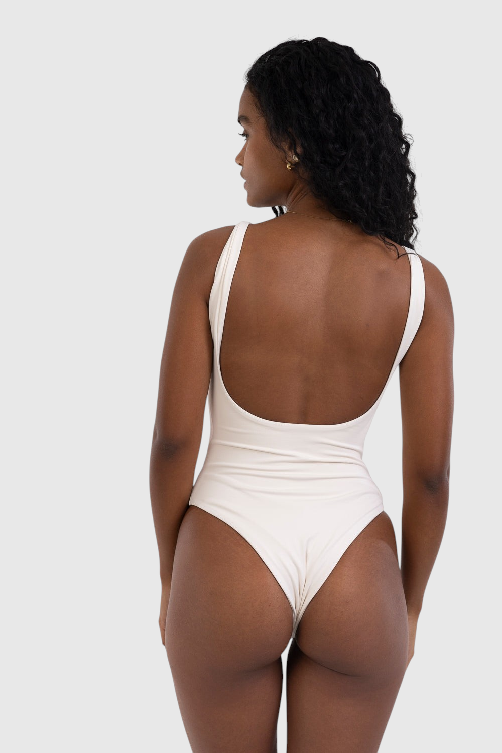 Modelo de costas vestindo body cavado off-white da LA MAGIE | Roupas Femininas Básicas e Estilosas com decote aberto