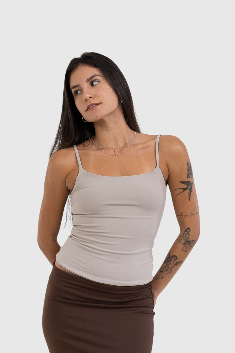 Modelo vestindo blusa regata bege de alça fina LA MAGIE | Roupas Femininas Básicas e Estilosas em suplex de poliamida.
