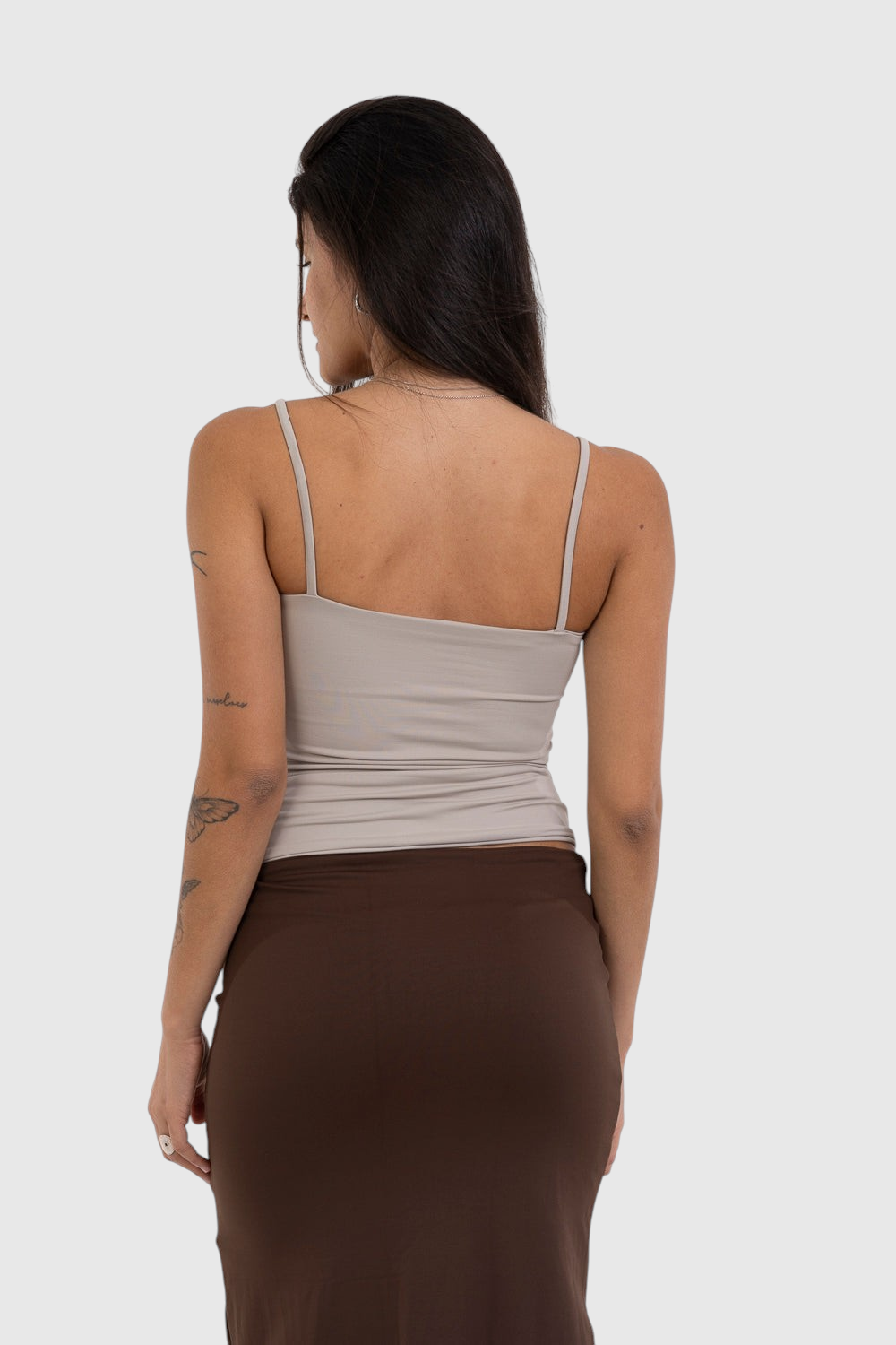 Modelo de costas vestindo blusa regata bege de alça fina em suplex de poliamida da LA MAGIE | Roupas Femininas Básicas e Estilosas