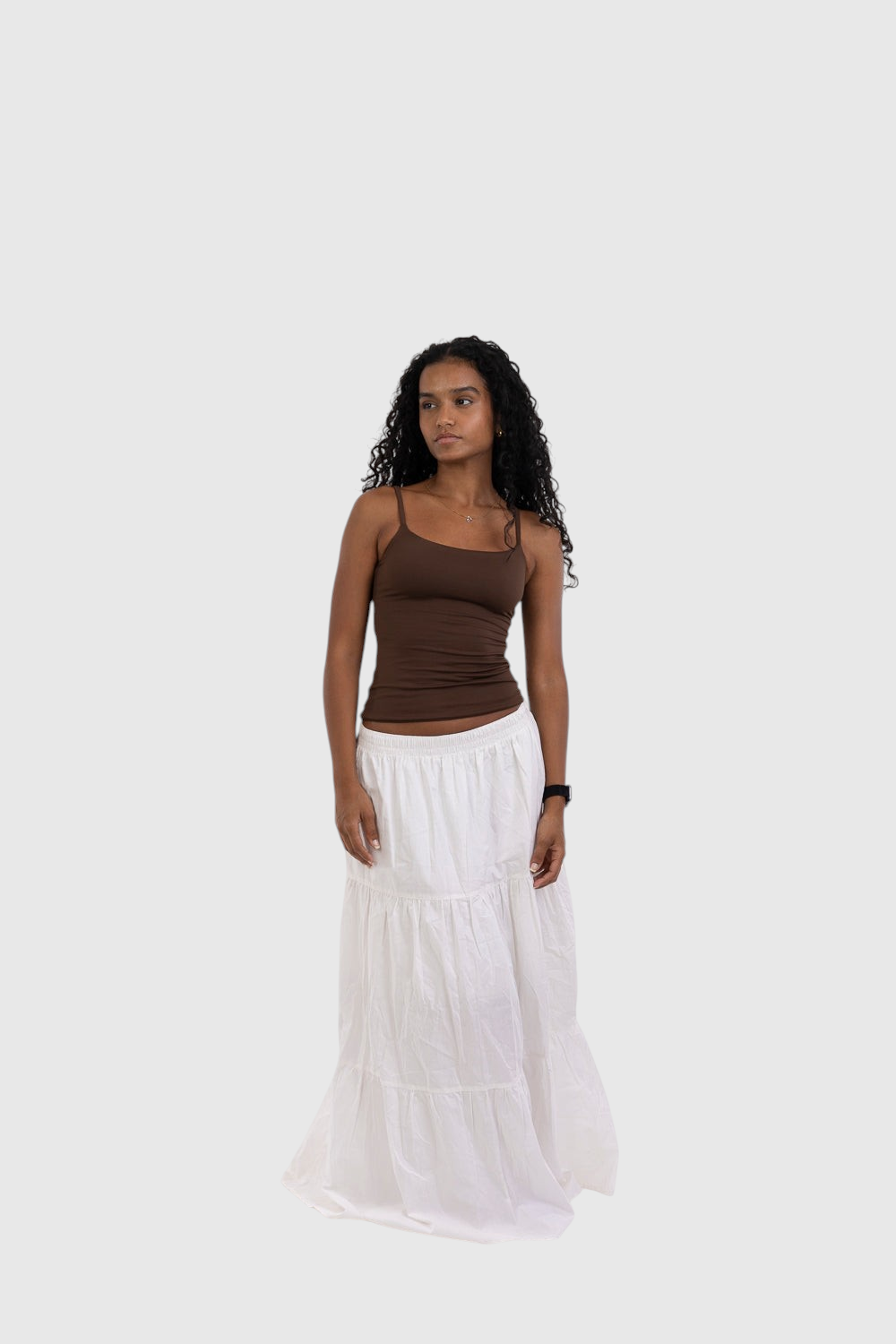Modelo veste blusa regata marrom de alça fina LA MAGIE | Roupas Femininas Básicas e Estilosas com saia longa branca