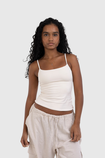 Modelo vestindo blusa regata off-white de alça fina LA MAGIE | Roupas Femininas Básicas e Estilosas em suplex premium