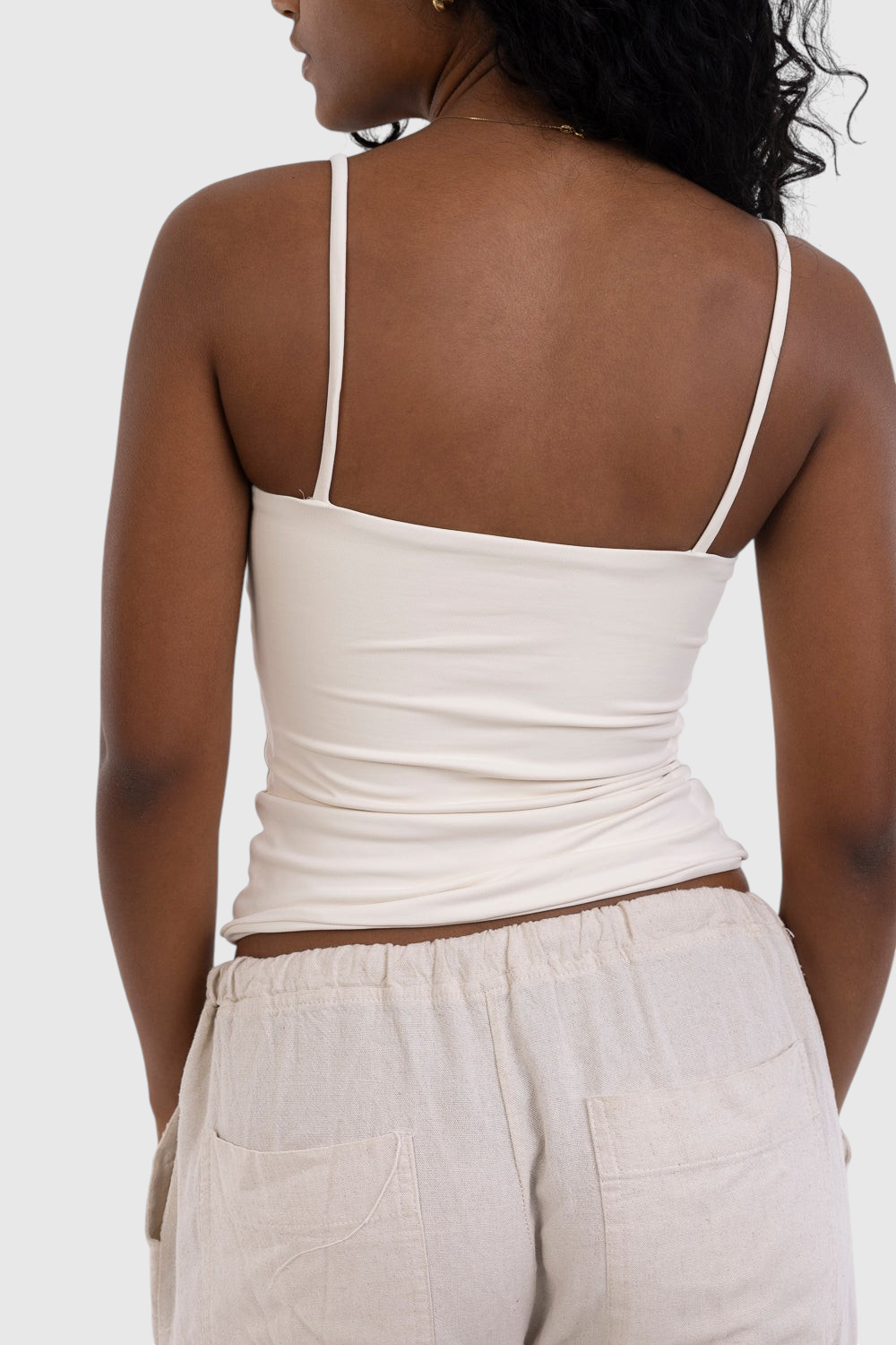 Modelo vestindo blusa regata de alça fina off-white LA MAGIE | Roupas Femininas Básicas e Estilosas em suplex premium