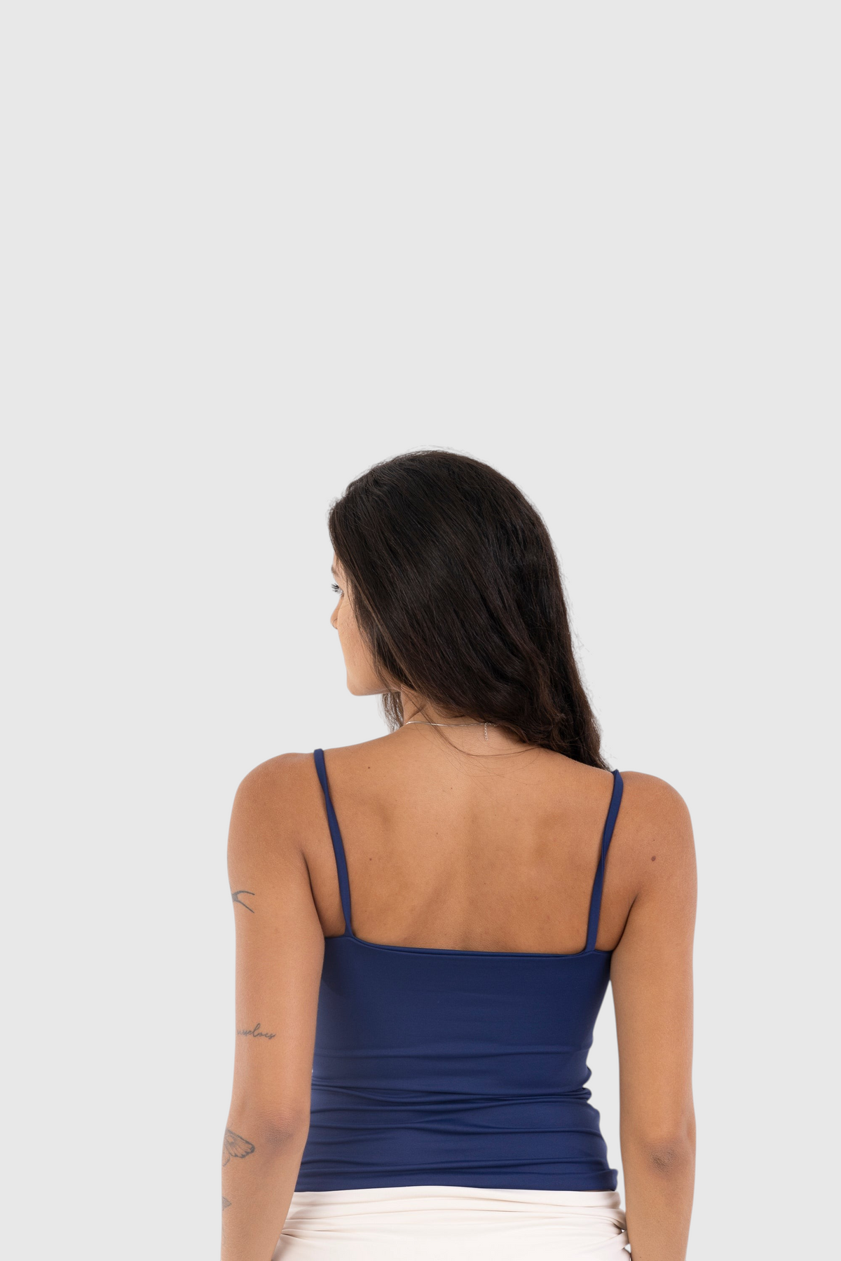 Vista traseira de modelo usando blusa regata azul de alça fina LA MAGIE | Roupas Femininas Básicas e Estilosas