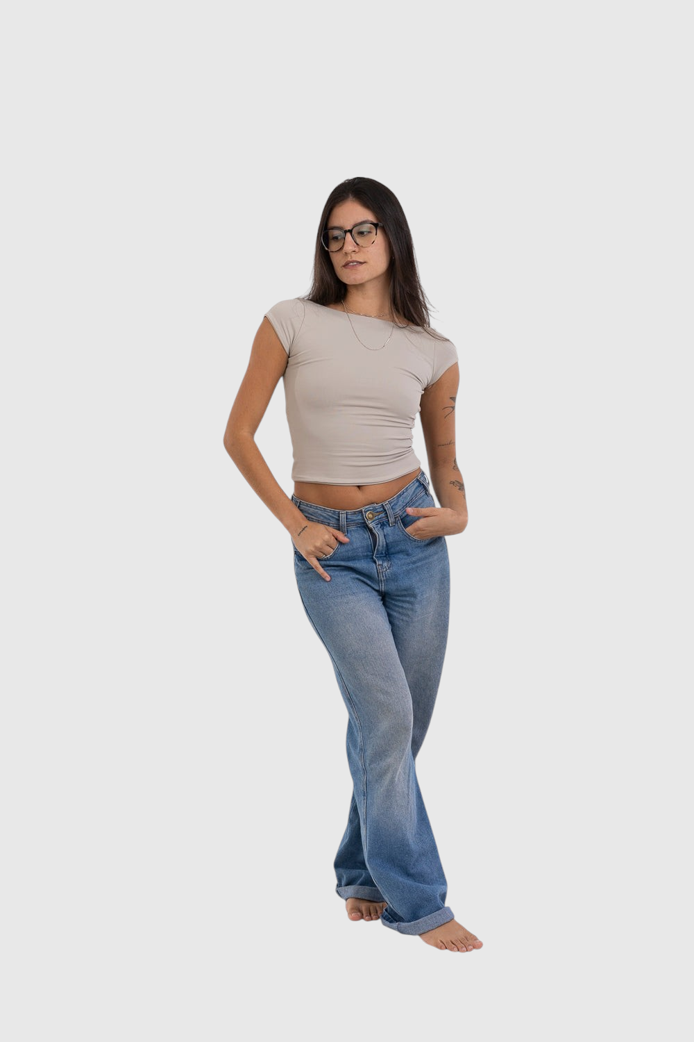 Modelo vestindo blusa bege de manga curta LA MAGIE com costas abertas em suplex de poliamida, combinada com jeans.