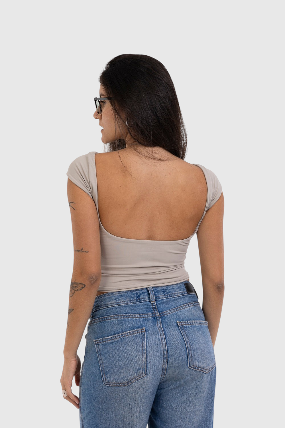 Modelo veste blusa bege LA MAGIE | Roupas Femininas Básicas e Estilosas de manga curta com decote aberto nas costas