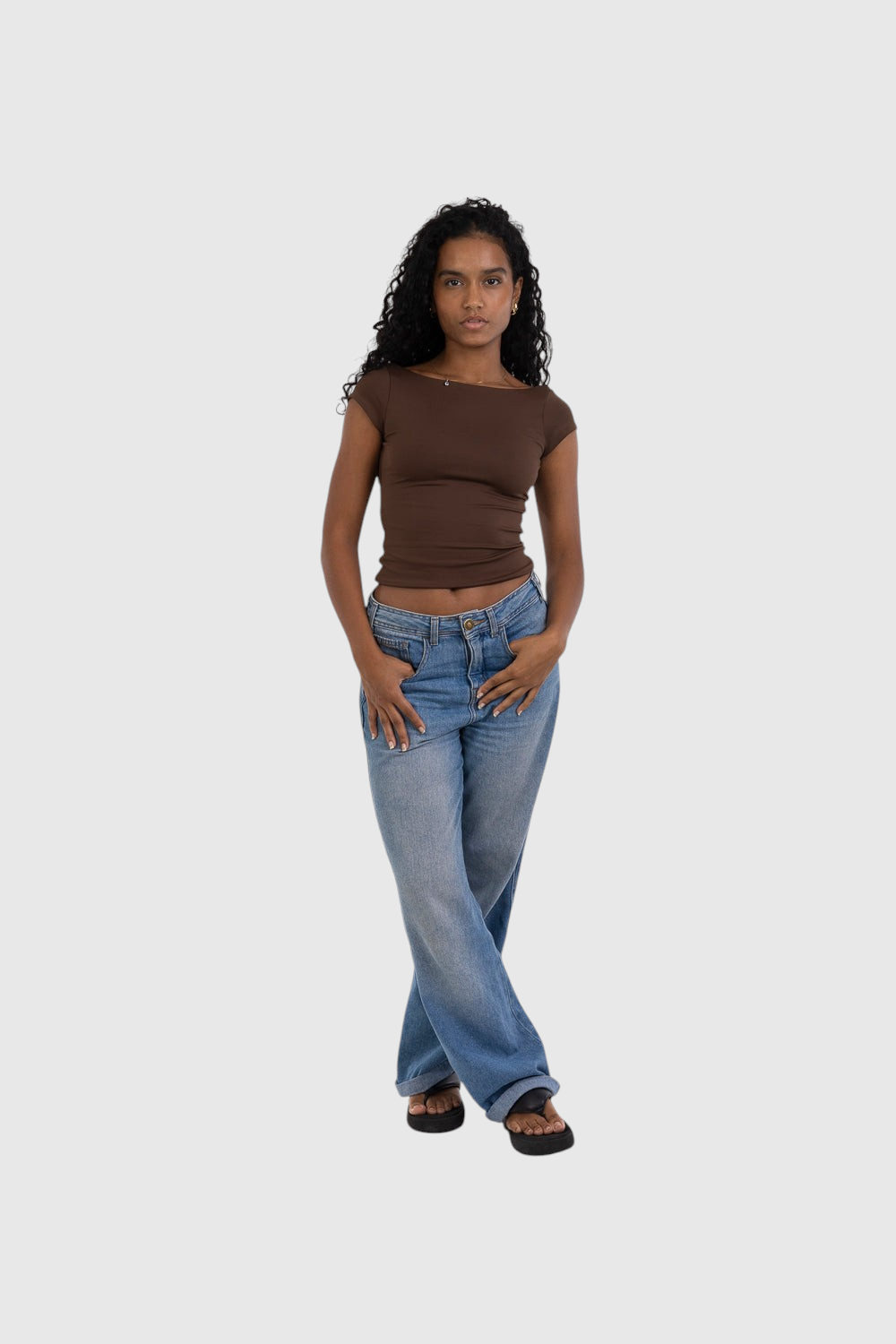 Modelo vestindo blusa marrom de manga curta LA MAGIE em suplex de poliamida com ajuste segunda pele e calça jeans