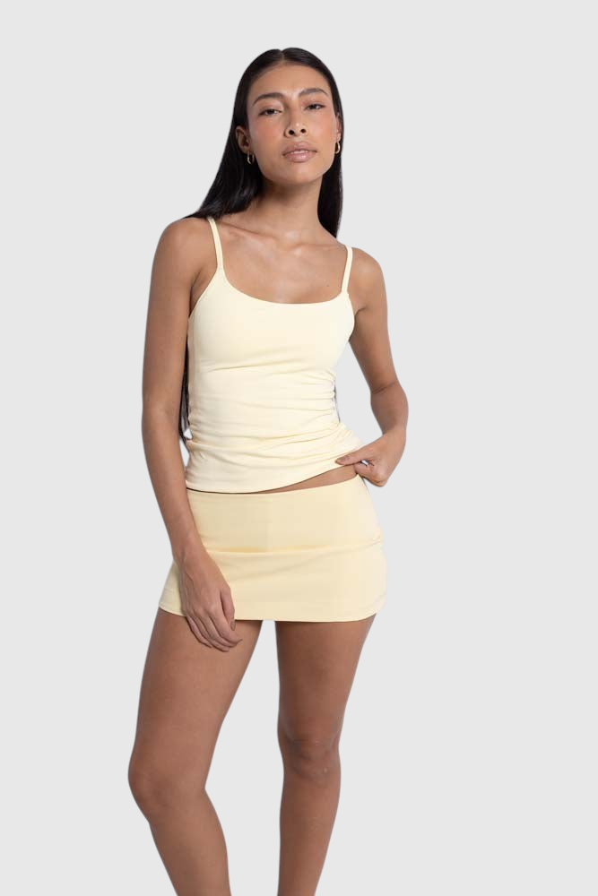Modelo vestindo mini saia Isis de alfaiataria amarela da LA MAGIE | Roupas Femininas Básicas e Estilosas com short interno