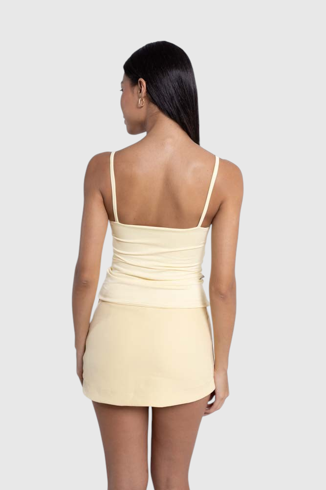 Modelo de costas vestindo blusa regata amarela de alça fina em suplex de poliamida da LA MAGIE | Roupas Femininas