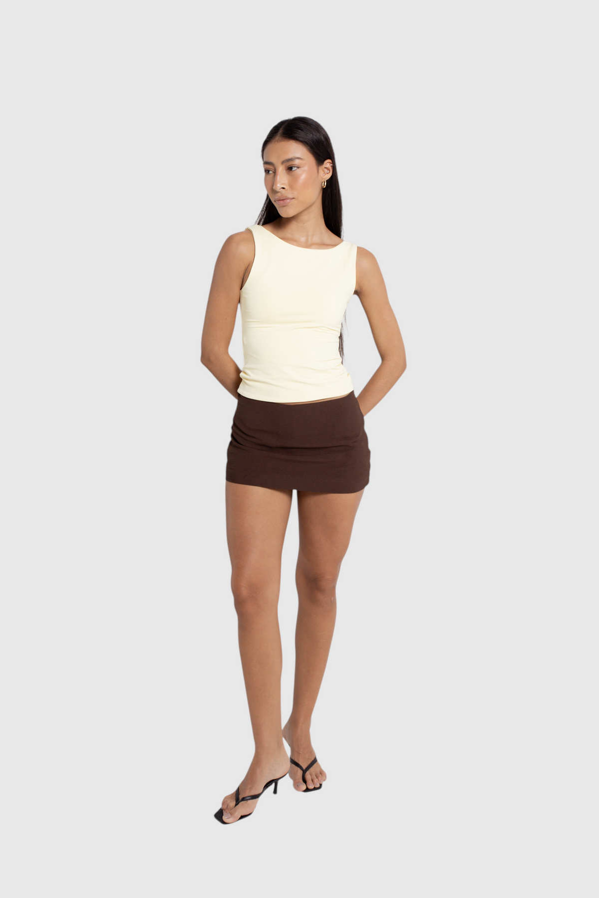 Modelo vestindo mini saia marrom de alfaiataria LA MAGIE | Roupas Femininas Básicas e Estilosas com short interno