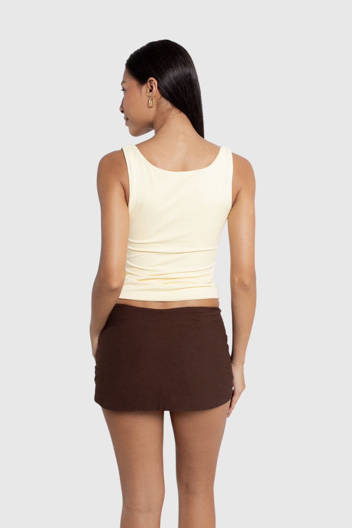 Modelo de costas vestindo blusa 2 em 1 amarela da LA MAGIE | Roupas Femininas Básicas e Estilosas em suplex premium.