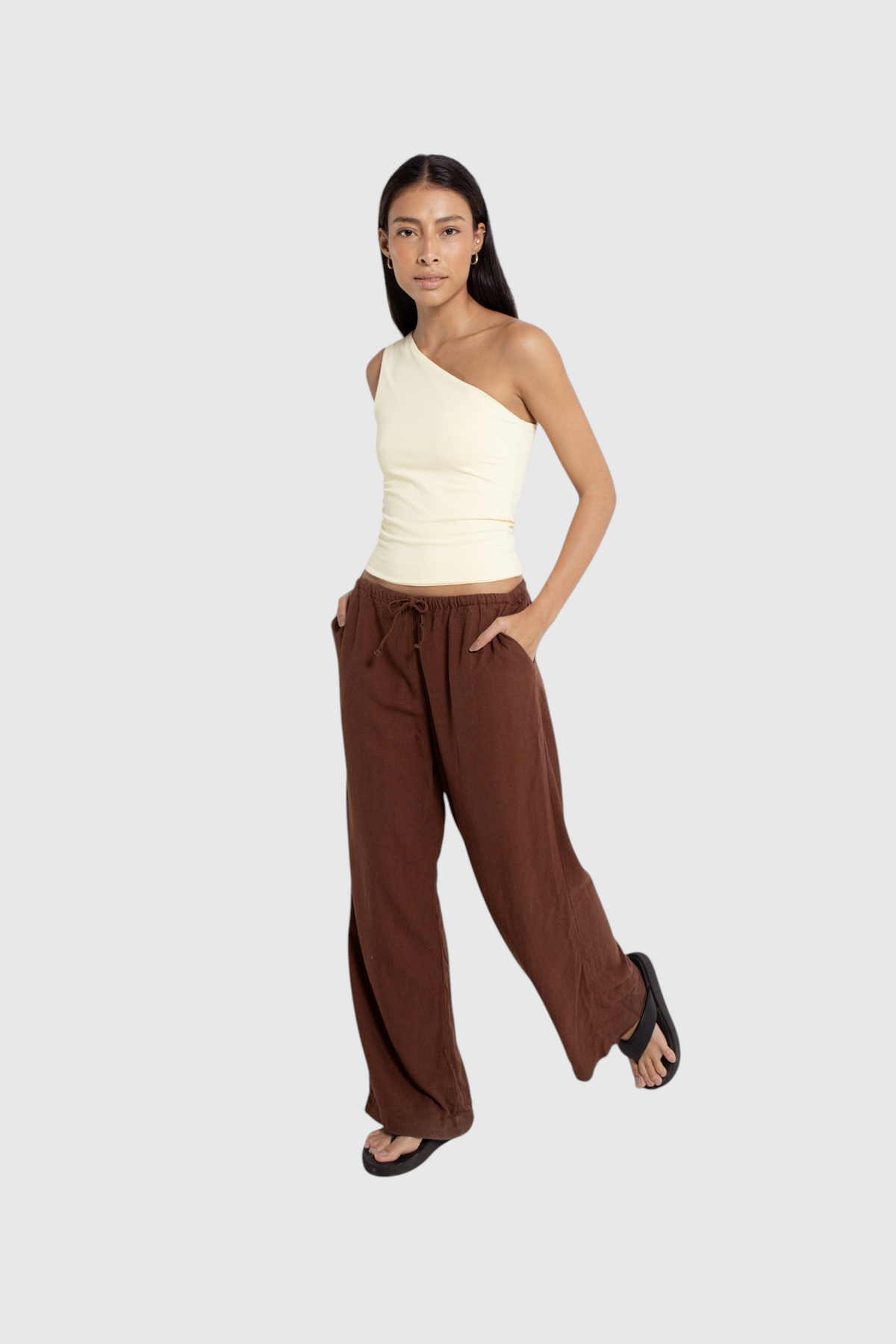 Modelo vestindo blusa nula manga off-white da LA MAGIE | Roupas Femininas Básicas e Estilosas com calça marrom