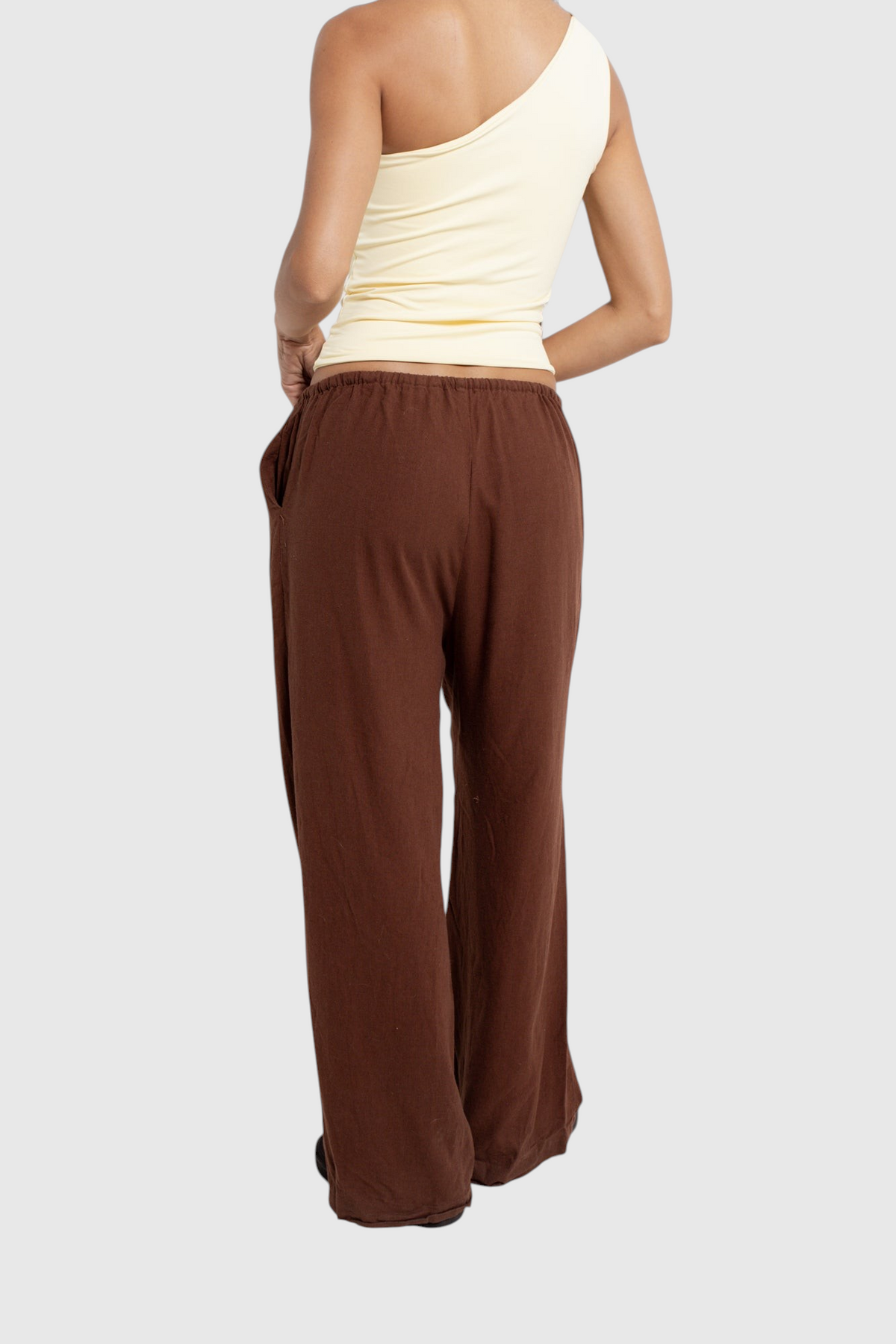 Modelo veste calça básica de linho marrom LA MAGIE | Roupas Femininas Básicas e Estilosas com corte amplo e bolsos.