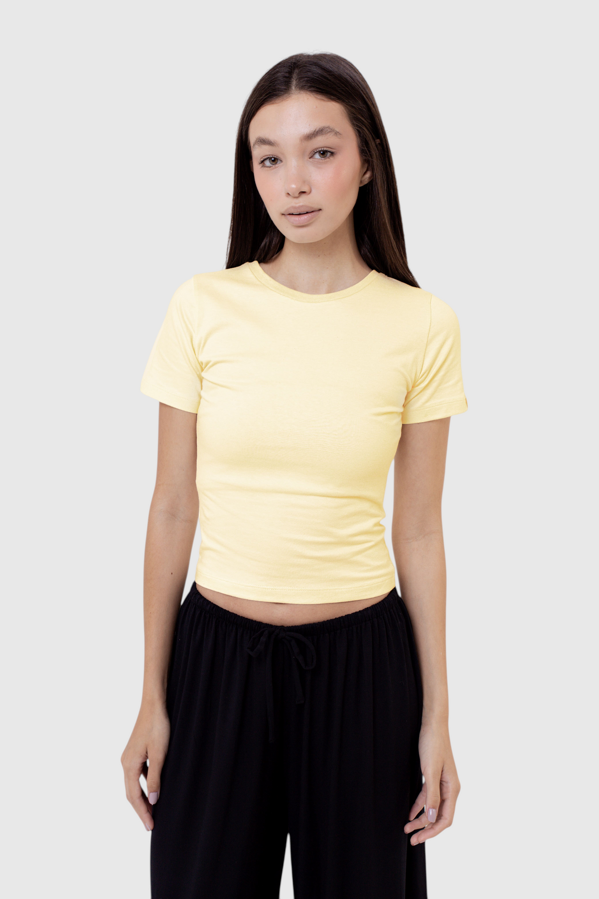 Modelo vestindo baby tee amarela de algodão da LA MAGIE | Roupas Femininas Básicas e Estilosas com corte ajustado