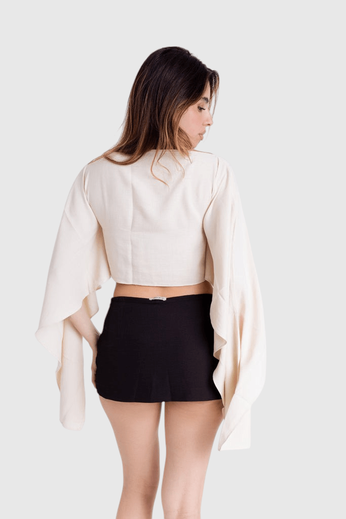 Modelo veste blusa Aura capa off-white de viscose rústica com mangas amplas e caimento fluido da LA MAGIE | Roupas Femininas Básicas e Estilosas