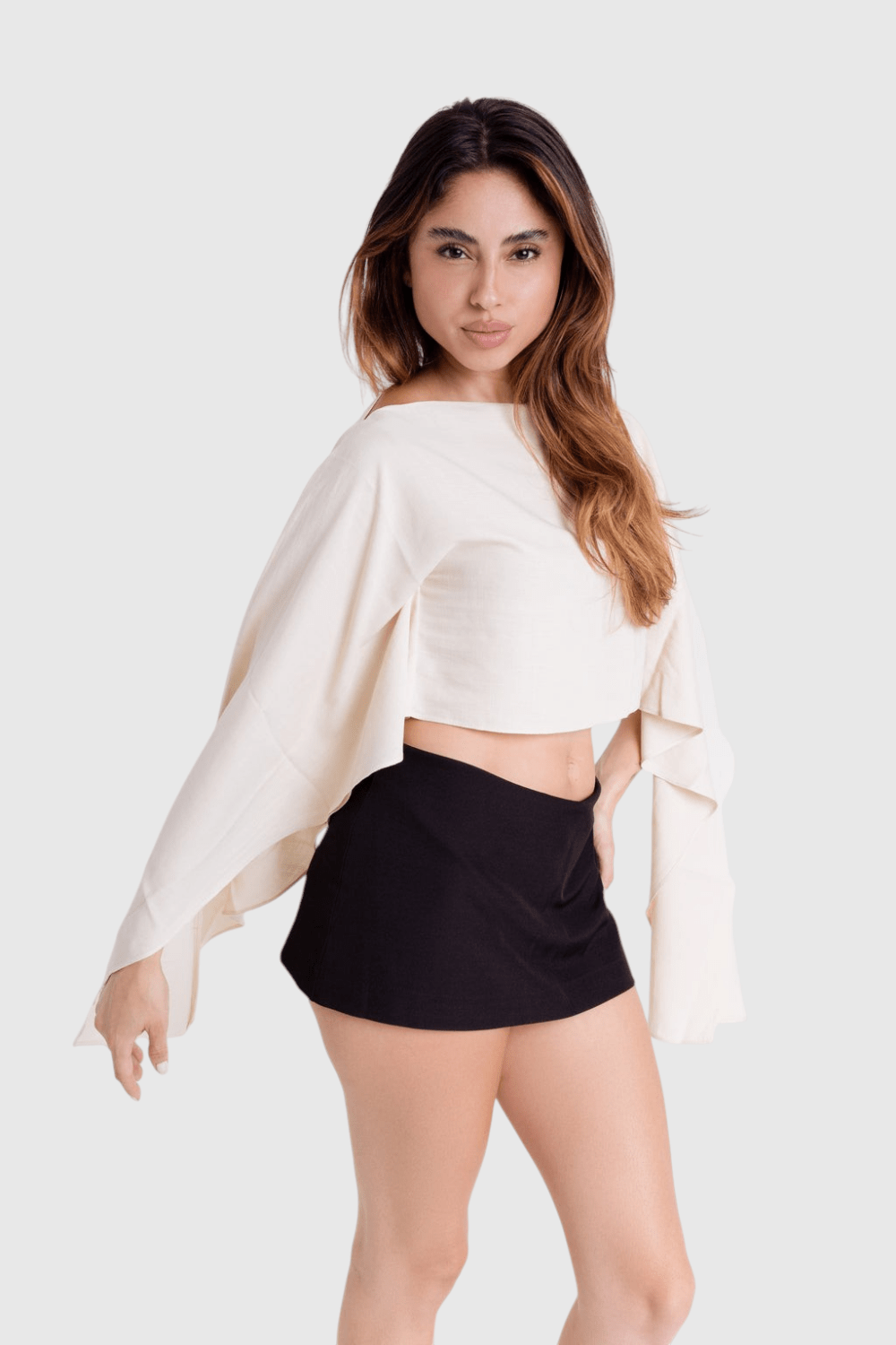 Modelo veste blusa Aura estilo capa off-white de viscose rústica com modelagem ampla e mangas fluidas da LA MAGIE
