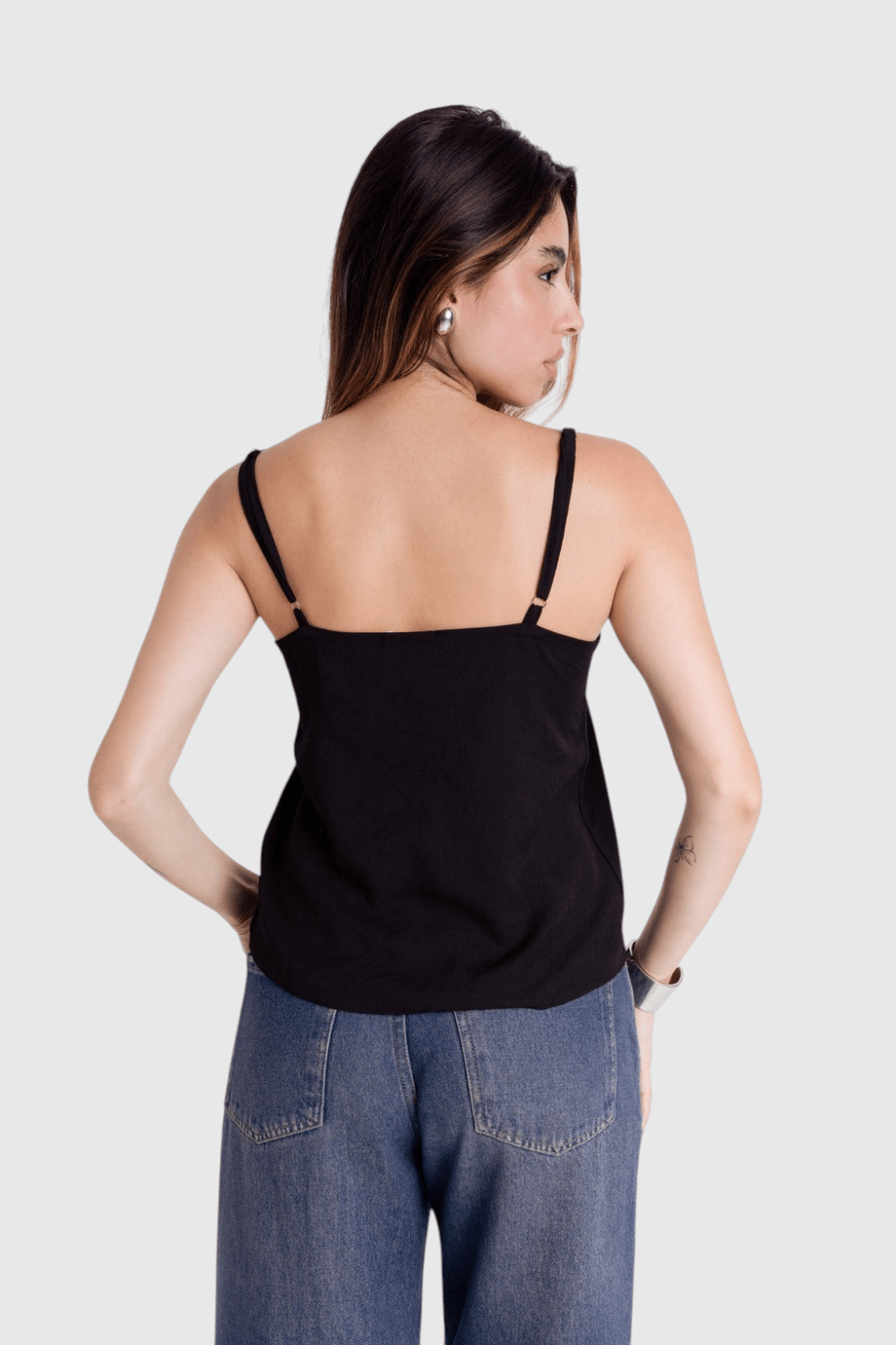 Modelo de costas vestindo blusa preta de alça fina com regulagem da LA MAGIE | Roupas Femininas Básicas e Estilosas