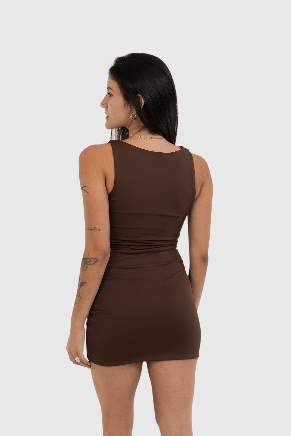 Modelo de costas vestindo vestido curto marrom LA MAGIE | Roupas Femininas Básicas e Estilosas em malha de poliamida