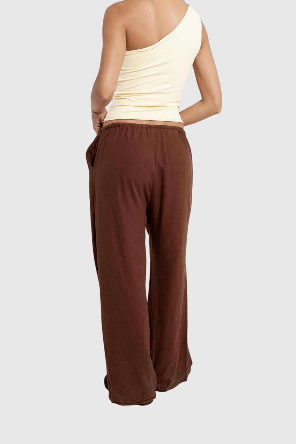 Modelo veste calça básica de linho marrom LA MAGIE | Roupas Femininas Básicas e Estilosas com corte amplo e bolsos.