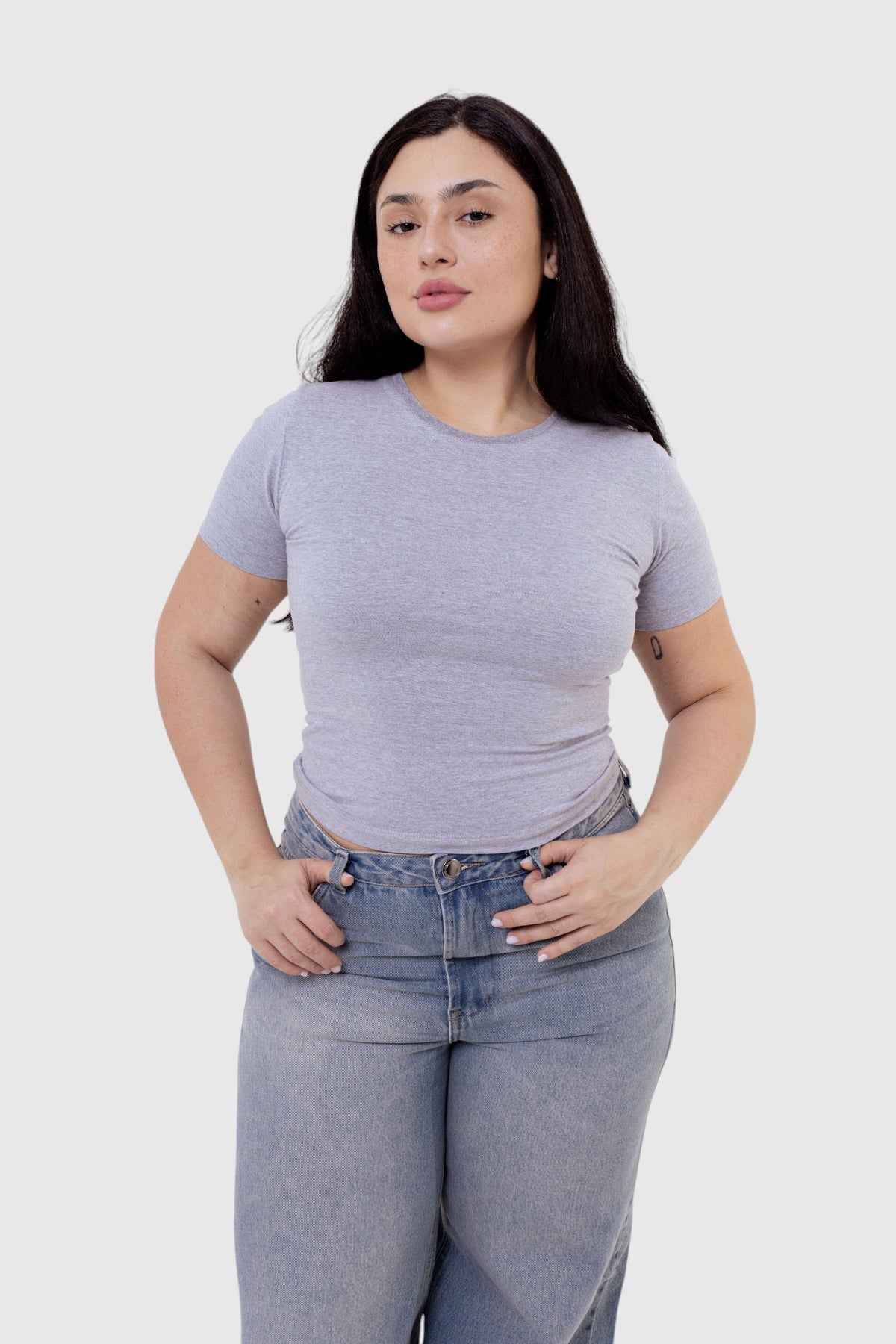 Modelo vestindo baby tee cinza de algodão da LA MAGIE | Roupas Femininas Básicas e Estilosas com calça jeans