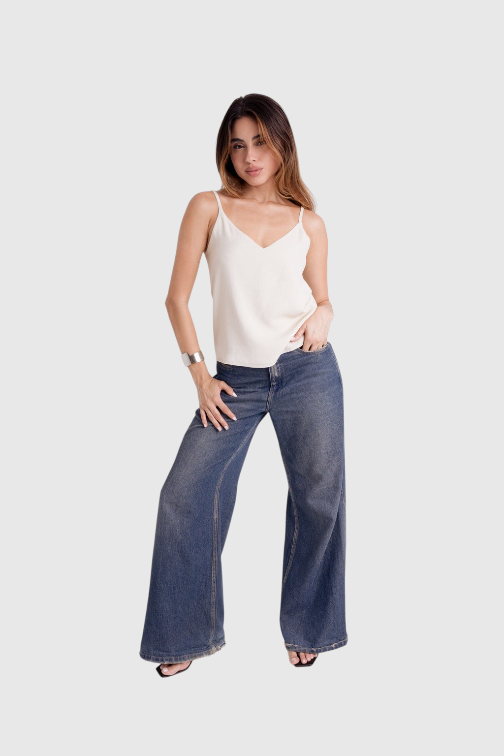 Modelo veste blusa LA MAGIE off-white de viscose rústica com decote em V, alças finas reguláveis e caimento solto.