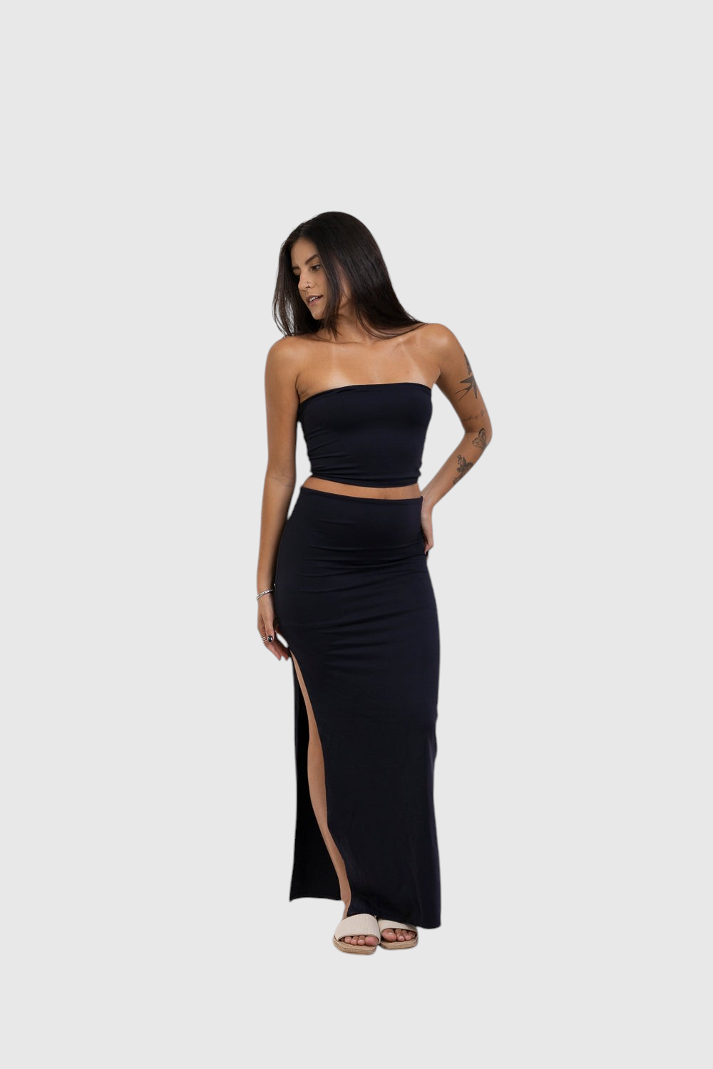 Modelo veste saia midi preta com fenda lateral da LA MAGIE | Roupas Femininas Básicas e Estilosas em malha poliamida