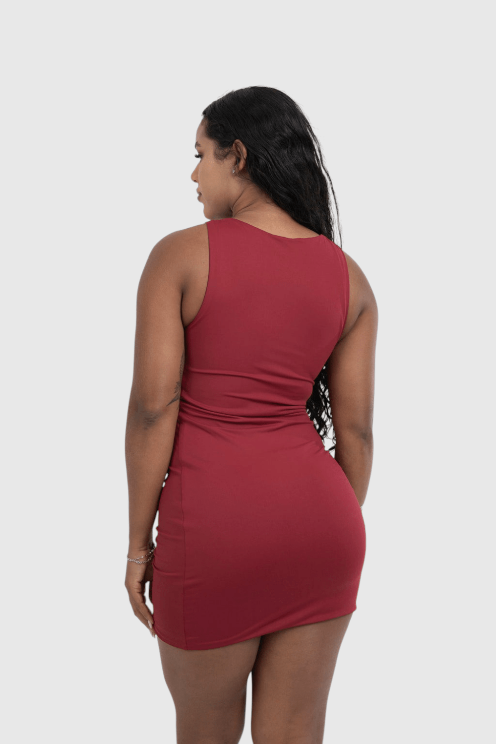 Modelo de costas vestindo vestido curto vermelho LA MAGIE em malha de poliamida com decote canoa e caimento ajustado.
